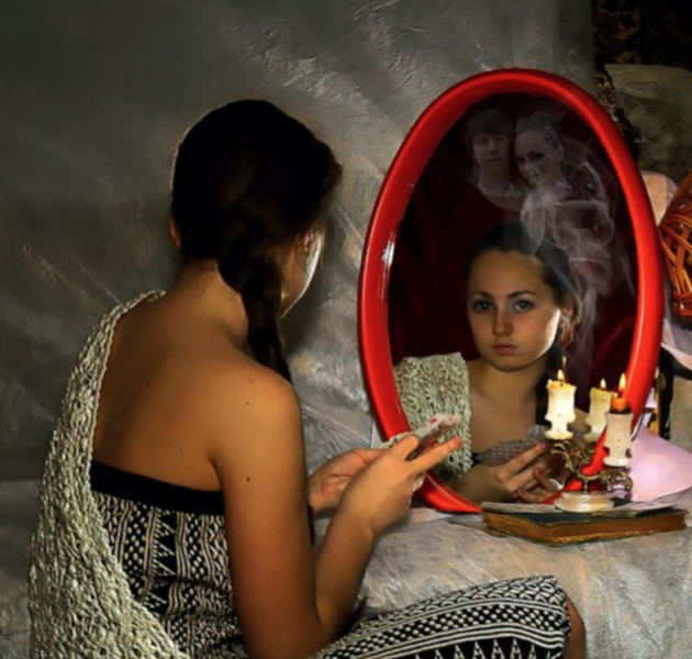 Девушка смотрится в зеркало