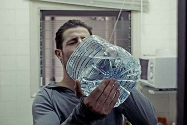 Мужчина пьет воду из канистры